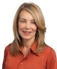 Headshot: Woman in coral top smiling at the camera